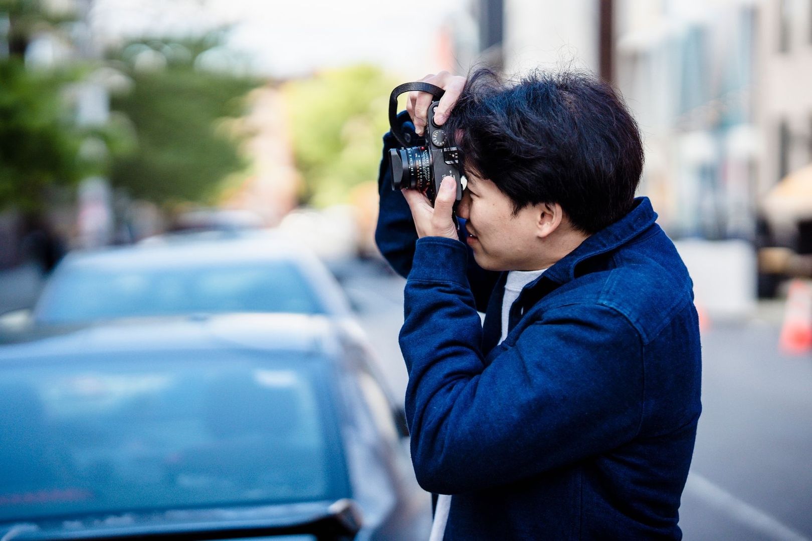 Persona fotografía una escena urbana con una cámara réflex