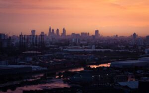 Panorámica urbana al atardecer con edificios y un canal reflejando luz cálida